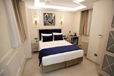a bedroom with a large bed with blue and white sheets at OMMA HOTEL in Istanbul