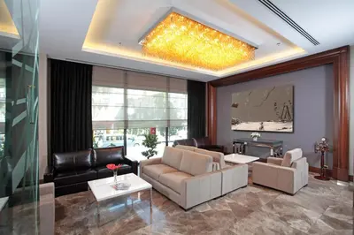 a living room with leather furniture and a chandelier at Istanbul Dora Hotel in Istanbul
