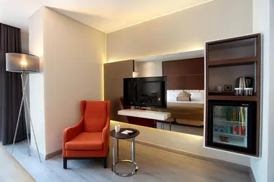 a hotel room with a red chair and a bed at Istanbul Dora Hotel in Istanbul