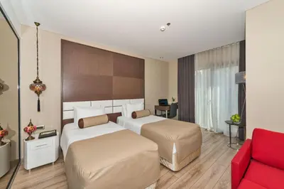 a hotel room with two beds and a red couch at Istanbul Dora Hotel in Istanbul