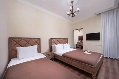 a hotel room with two beds and a television at taxim cool in Istanbul