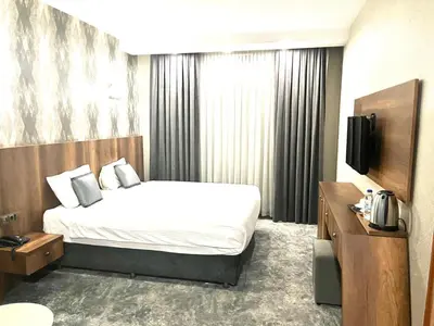 a hotel room with a bed and a television at Istanbul Airport Express Hotel in Arnavutköy