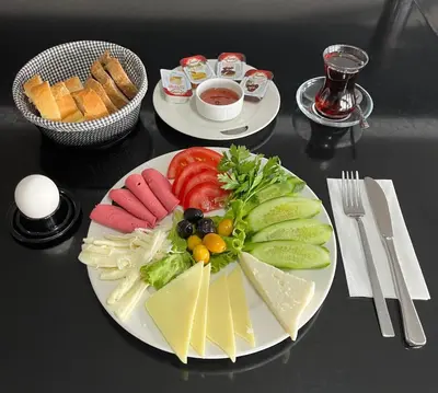 a black table with two plates of cheese and vegetables at Istanbul Airport Express Hotel in Arnavutköy