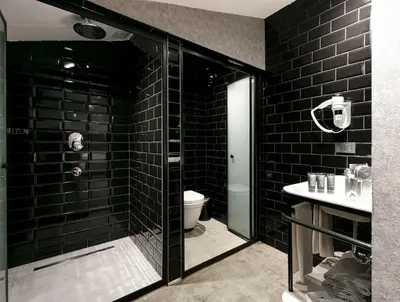 a black bathroom with a shower and a toilet at Avantgarde Urban Sisli in Istanbul