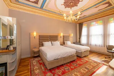 a bedroom with two beds and a chandelier at Blue Gilroy Hotel in Istanbul