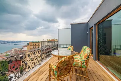 a balcony with a table and chairs and a view of the water at Istanbul Taksim Residence Hotel By MESUT in Istanbul