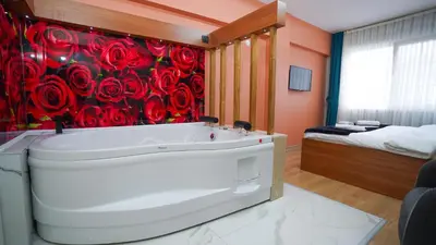 a bathroom with a white bath tub and red roses wallpaper at Luka Suit Hotel in Istanbul