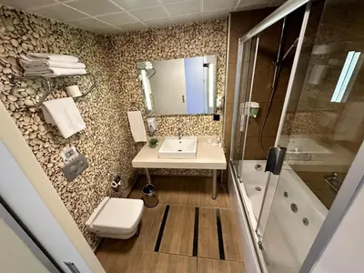 a bathroom with a sink and a shower and a toilet at Tempo Suites Airport in Istanbul