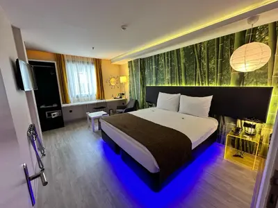 a bedroom with a large bed with a blue light at Tempo Suites Airport in Istanbul
