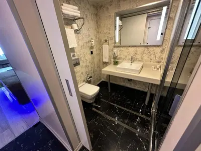 a bathroom with a sink and a toilet and a mirror at Tempo Suites Airport in Istanbul