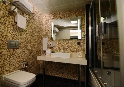 a bathroom with a toilet and a sink and a mirror at Tempo Suites Airport in Istanbul