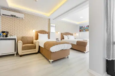 a hotel room with two beds and a chair at BLUE MARMARA SUITES in Istanbul