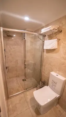 a bathroom with a shower with a toilet and a glass shower stall at DYMAR HOTEL in Istanbul