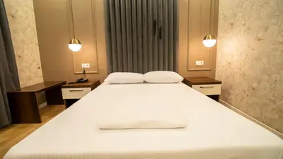 a large white bed in a room with two lights at DYMAR HOTEL in Istanbul