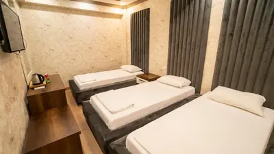 a room with three beds and a tv at DYMAR HOTEL in Istanbul