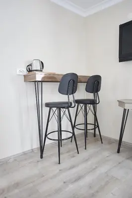 a table with two black chairs and a television at Luna Suites Taksim in Istanbul