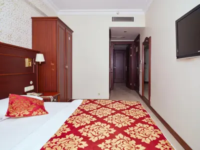 a bedroom with a bed with a red and gold bedspread at Istanbul Newcity Hotel in Istanbul