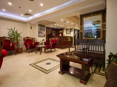 a living room with red chairs and a large mirror at Istanbul Newcity Hotel in Istanbul
