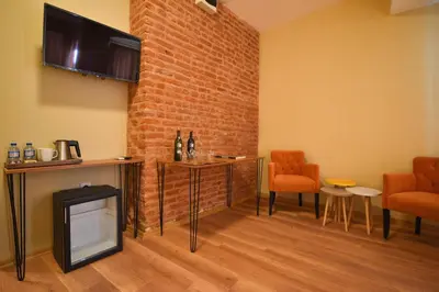 a living room with a tv and a brick wall at Maravilloso Hotel Pera in Istanbul