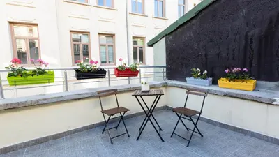 three chairs sitting on a balcony with potted plants at Maravilloso Hotel Pera in Istanbul