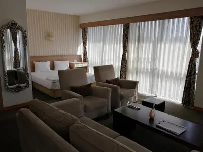 a hotel room with a bed and a couch and chairs at Nice Royal in Istanbul