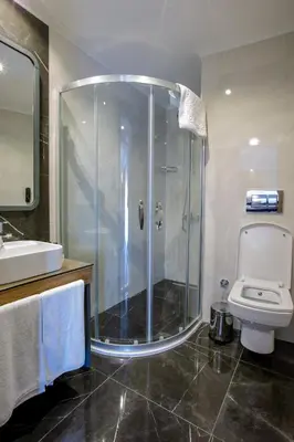 a bathroom with a shower and a toilet and a sink at Kayhan City Hotel in Bursa