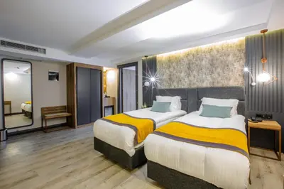 a hotel room with two beds and a mirror at Kayhan City Hotel in Bursa