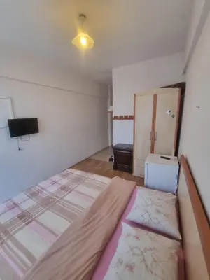 a bedroom with a large bed and a small cabinet at Thermal Orkide Pansiyon in Yalova