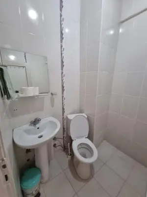 a white bathroom with a toilet and a sink at Thermal Orkide Pansiyon in Yalova