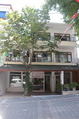 a building with a tree in front of it at Thermal Orkide Pansiyon in Yalova