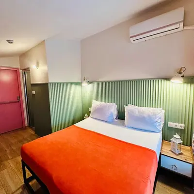 a bedroom with a large bed with an orange blanket at Casa Rosa Suites in Istanbul