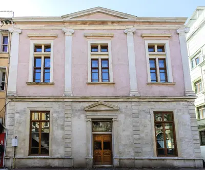 a pink building with windows on a city street at The Nomad Inn Old City İstanbul in Istanbul