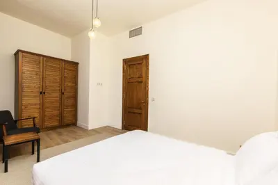 a bedroom with a white bed and a wooden cabinet at The Nomad Inn Old City İstanbul in Istanbul