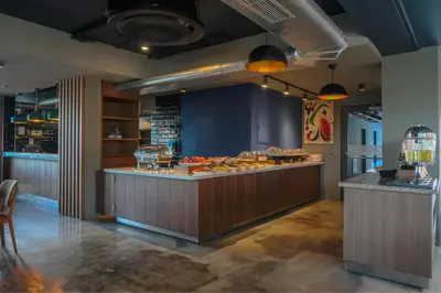 a restaurant with a counter with food on it at Four Points Flex by Sheraton Bursa Nilüfer in Bursa