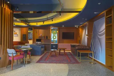 a living room with tables and chairs and a tv at Four Points Flex by Sheraton Bursa Nilüfer in Bursa