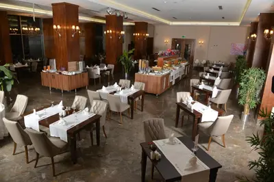 a restaurant with white tables and chairs and tablesearcher at Yalova Lova Hotel & SPA Yalova in Yalova
