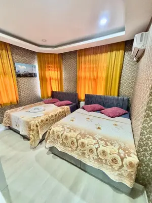 two beds in a room with orange curtains at İmmortal Hotel İstanbul in Istanbul