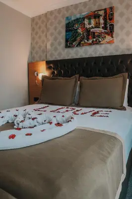 a large bed with red flowers on it at Otel Grand Lark İstanbul in Istanbul