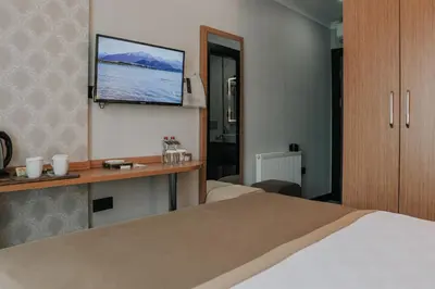 a hotel room with a bed and a tv on the wall at Otel Grand Lark İstanbul in Istanbul