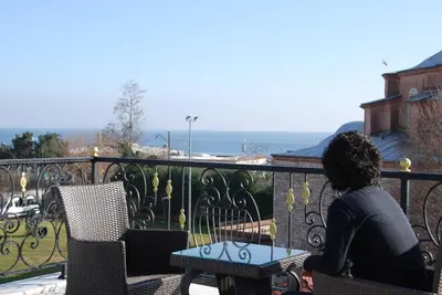 a woman sitting at a table on a balcony at Little sofia hotel in Istanbul