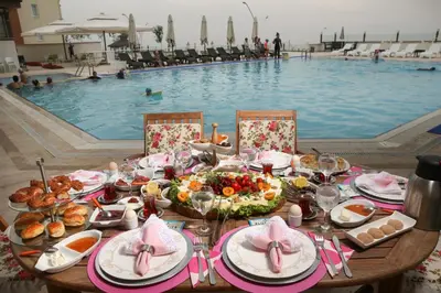 a table with food and a swimming pool at Blue Pier Hotel in Kocaeli