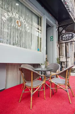 three chairs and a table on a red carpet at Armar Hotel in Istanbul