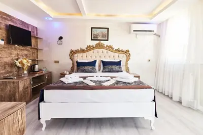 a bedroom with a large white bed with blue pillows at Armar Hotel in Istanbul
