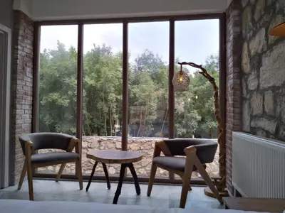 a room with two chairs and a table and a large window at İğneada Hotel Rezve in Kırklareli