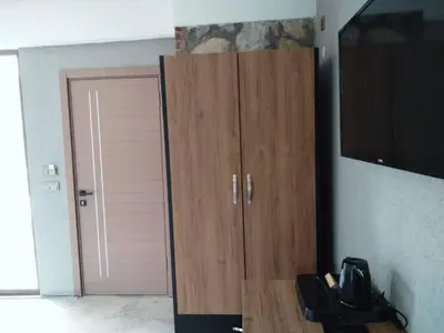 a room with a wooden cabinet and a television at İğneada Hotel Rezve in Kırklareli