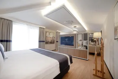 a hotel room with a large bed and a tv at GRANBELLAHOTEL in Tekirdag