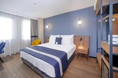 a hotel room with a bed and a blue wall at GRANBELLAHOTEL in Tekirdag