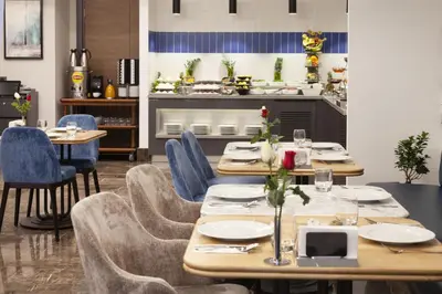 a dining room with wooden tables and blue chairs at GRANBELLAHOTEL in Tekirdag