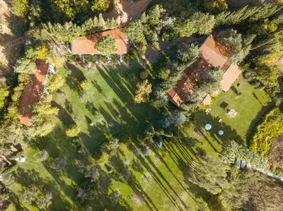 an overhead view of a field with a house and trees at The Lake House in Boyalıca