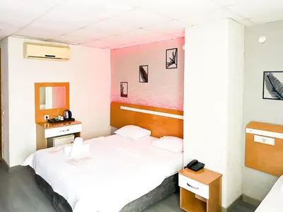 a hotel room with two beds and a mirror at Avcılar İnci Hotel in Istanbul